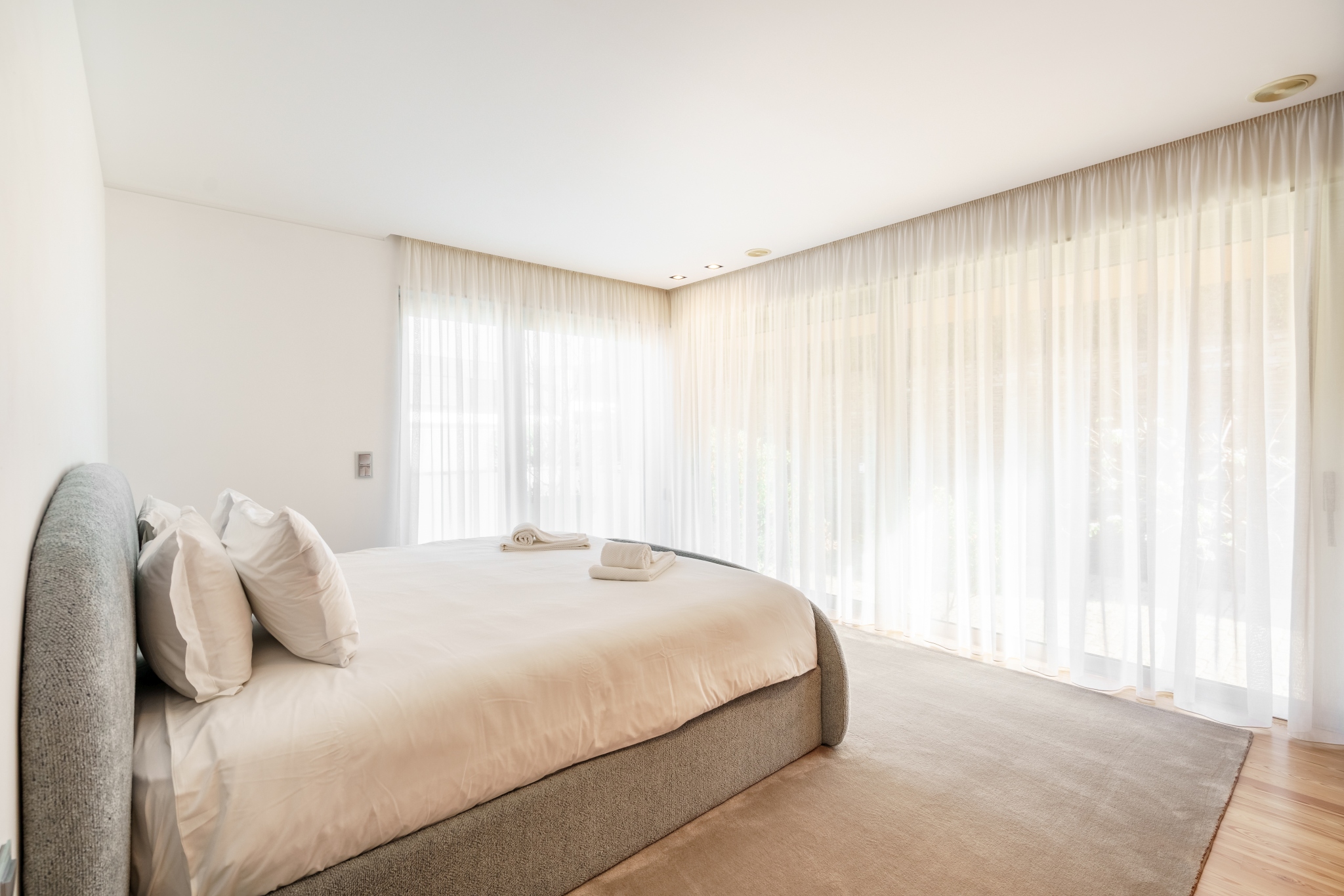 Courtyard Room — king bed wrapped by two walls of sheer linen.