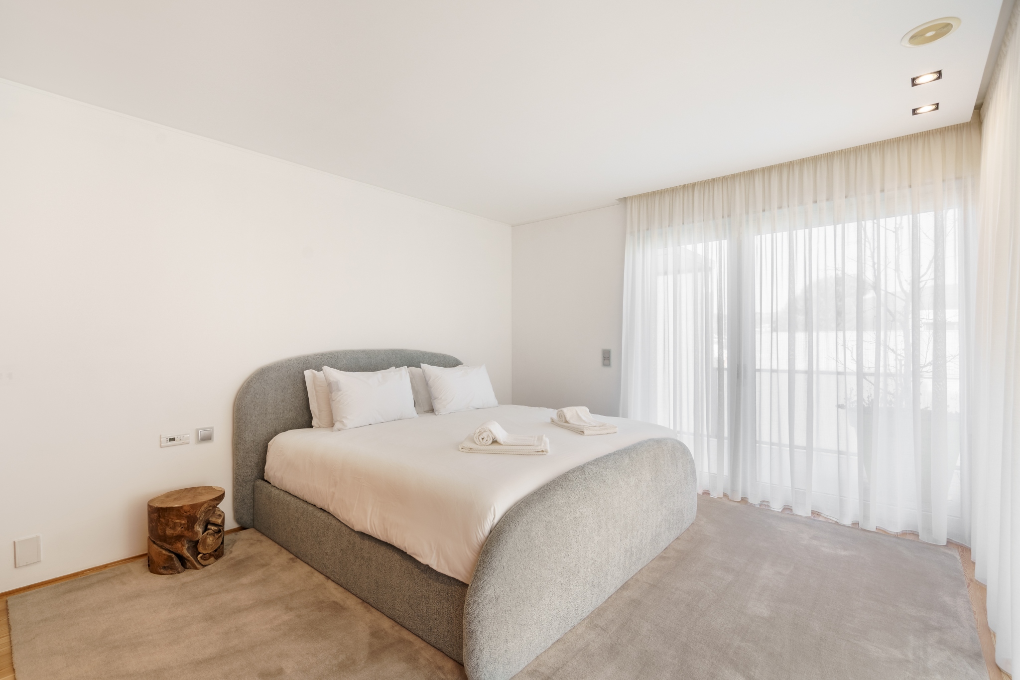 Courtyard Room — bed and dressing area in soft morning light.