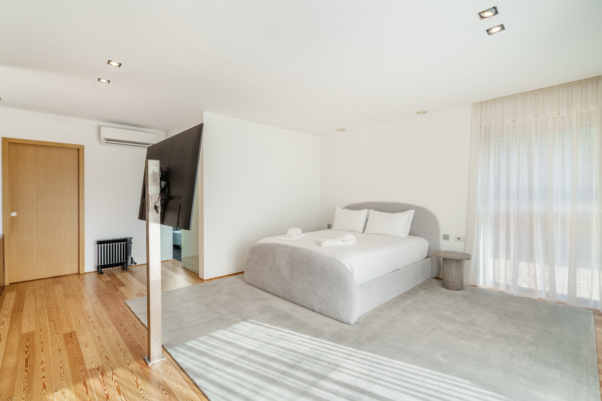 Garden Suite — bedroom with air-conditioning and a free-standing television.