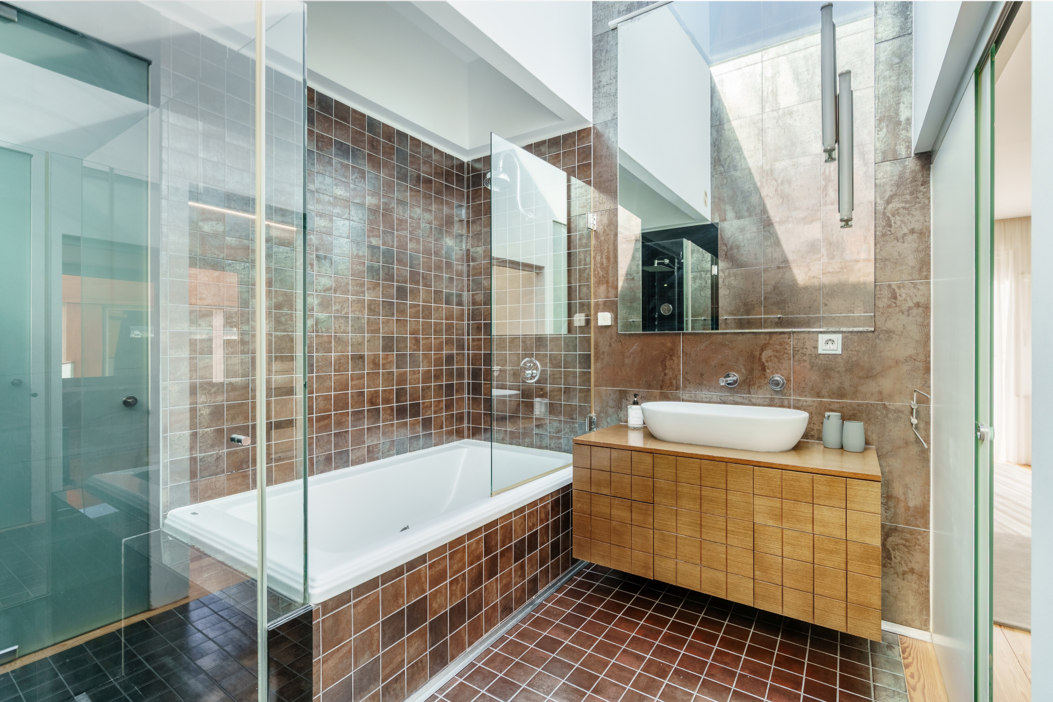 Garden Suite — ensuite with a bathtub and basin in dark mosaic stone.