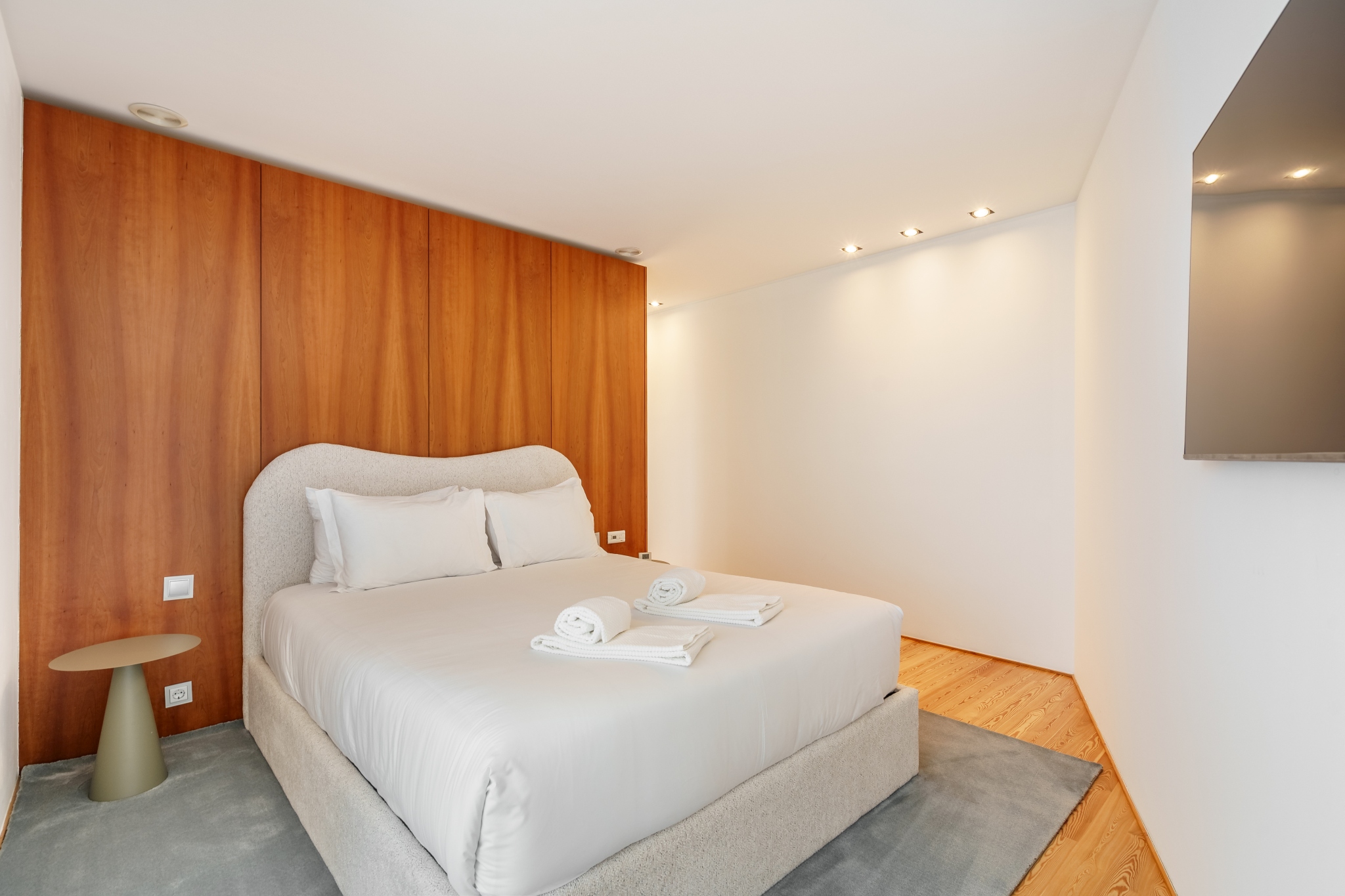 Quiet Suite — bed against a warm cherry-wood panelled wall.