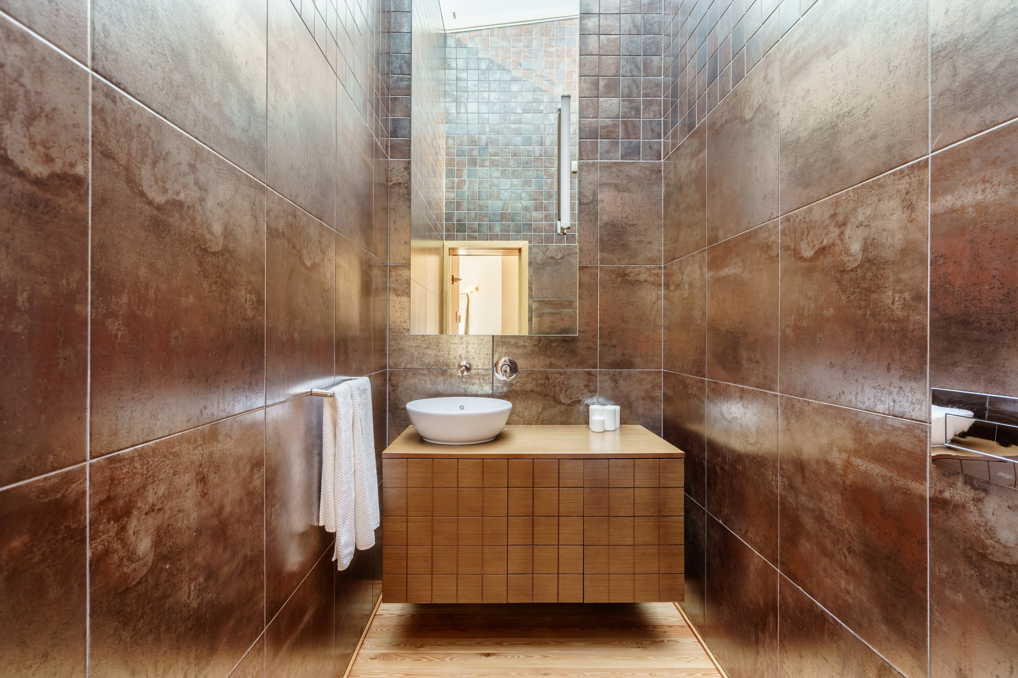 A stone-tiled bathroom with a freestanding vanity and walk-in shower.