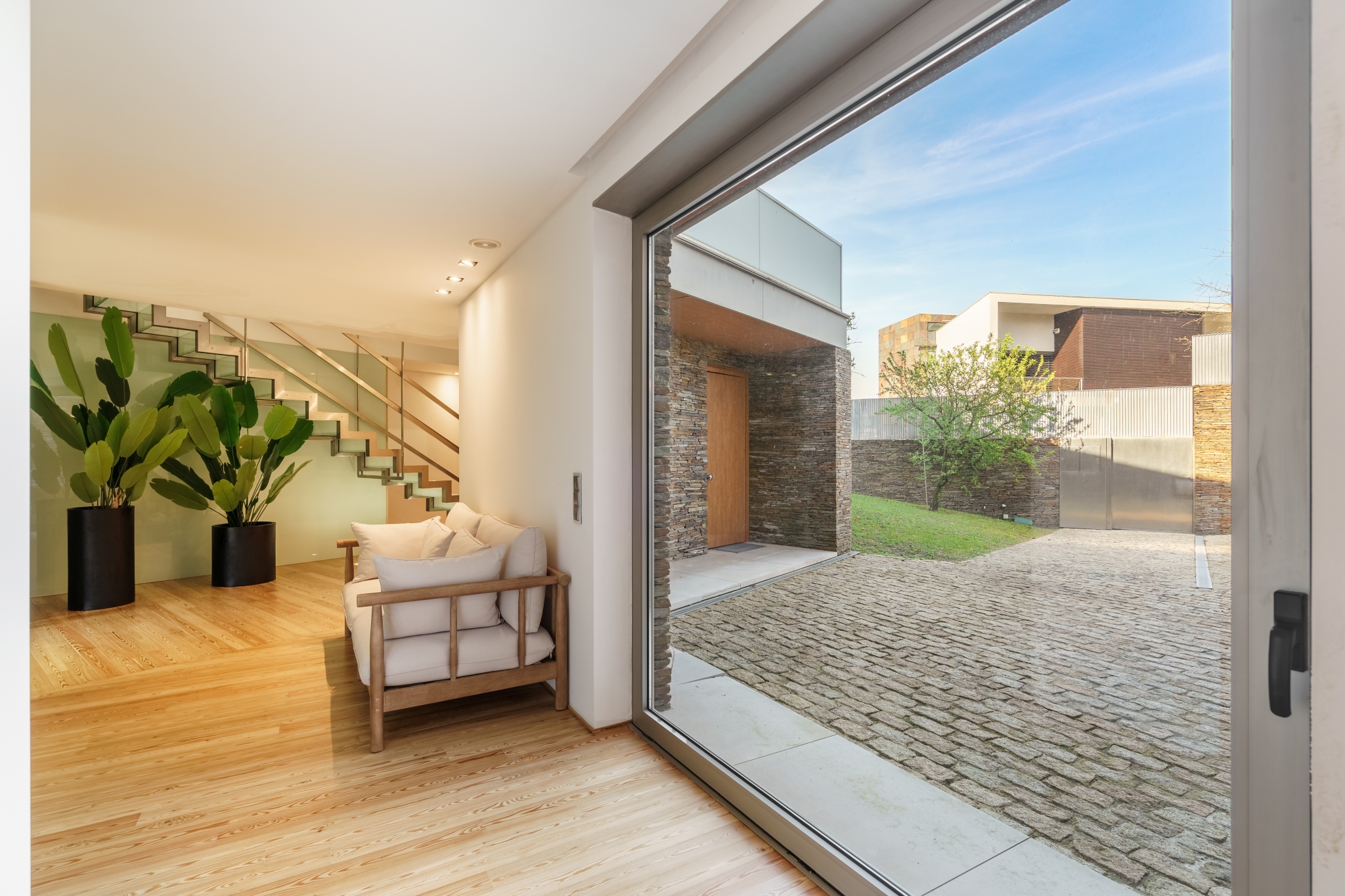 A living room opening through full-height glass onto the courtyard.