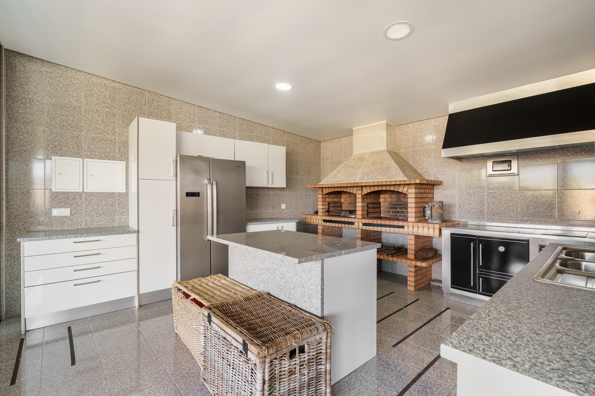 The Guest House — kitchen with a wood-fired grill and granite island.