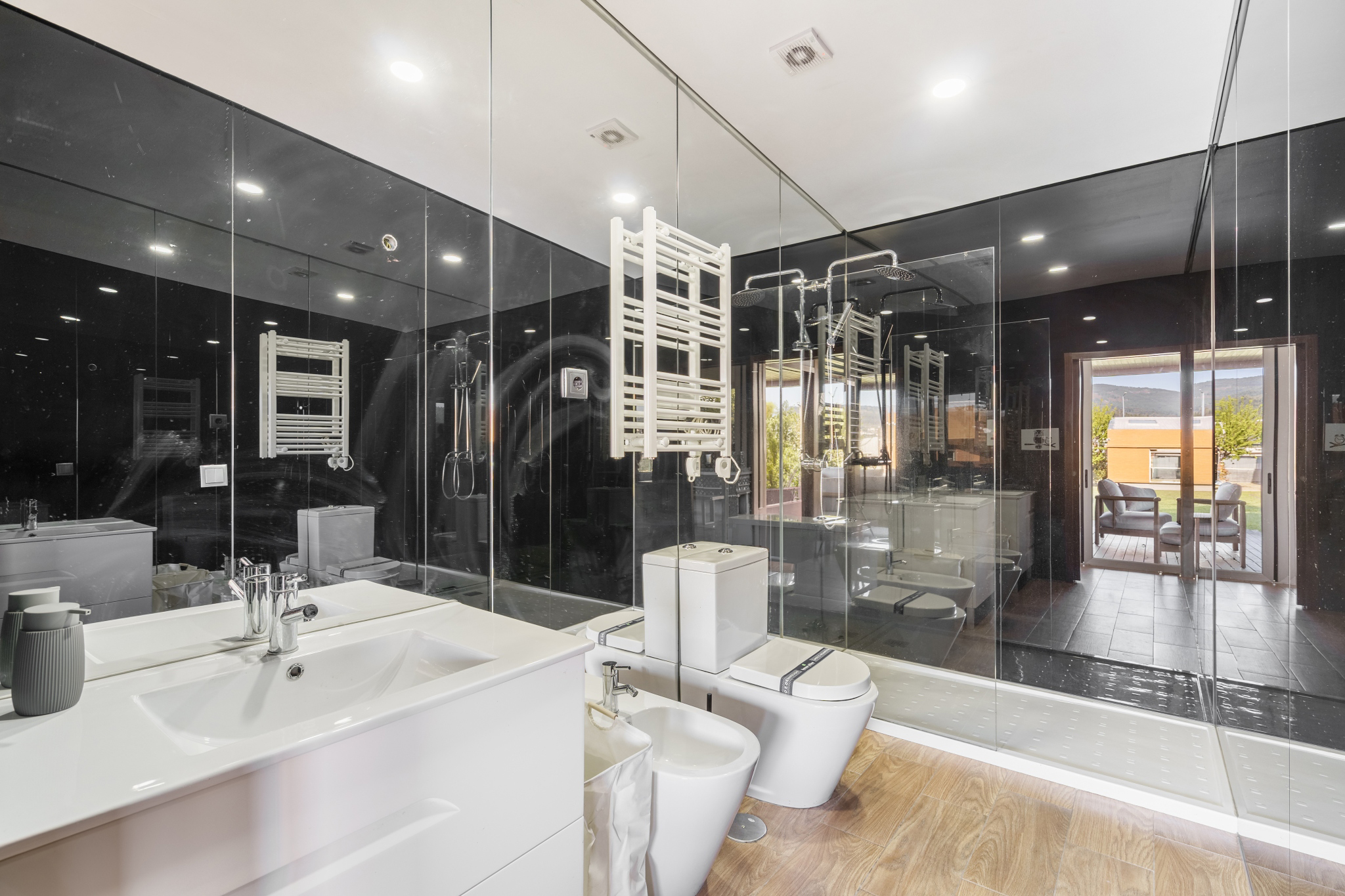 The Guest House — bathroom in black glass, opening to the deck.