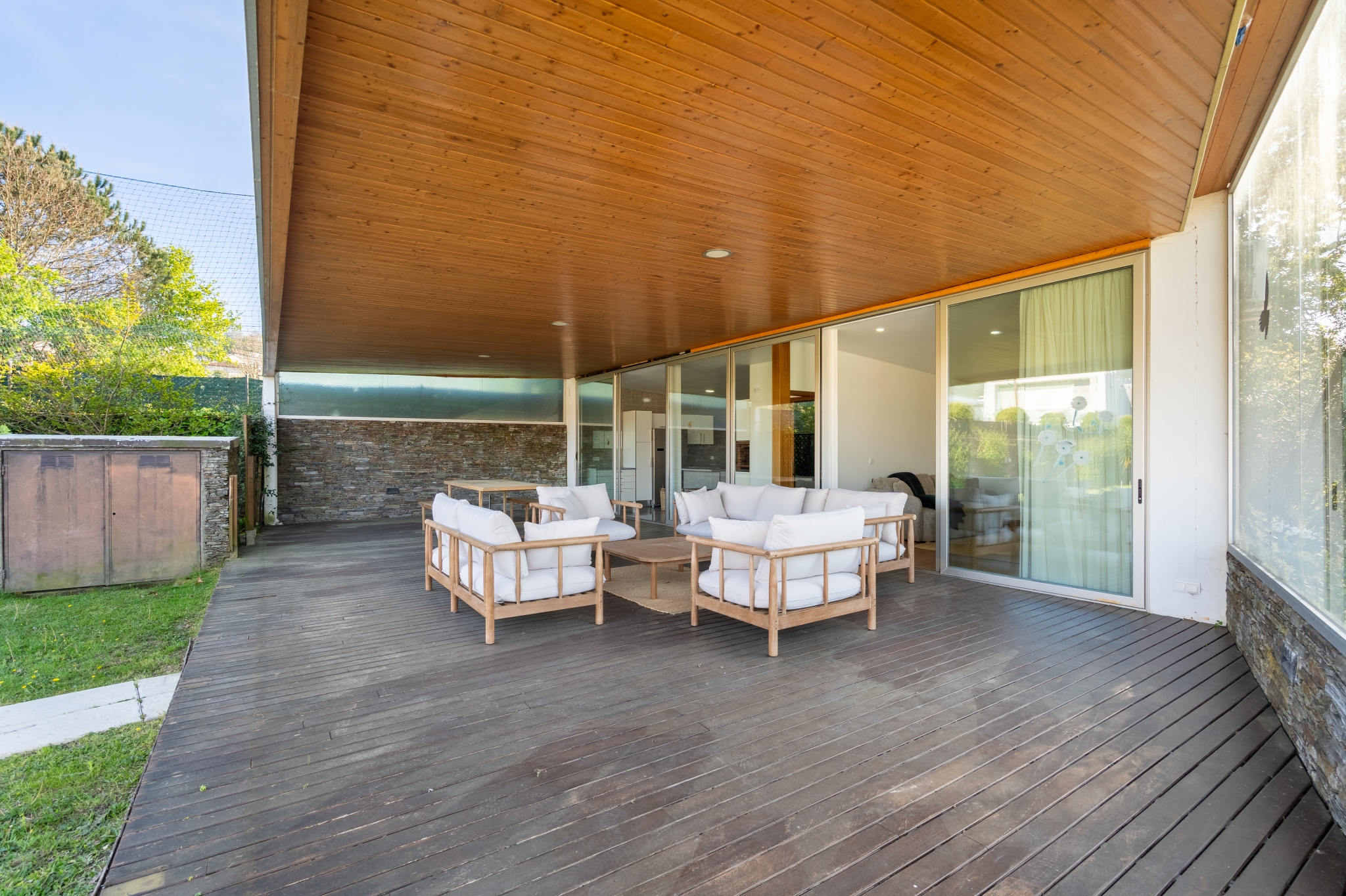 The covered terrace — timber ceiling, seating, looking out to the garden.