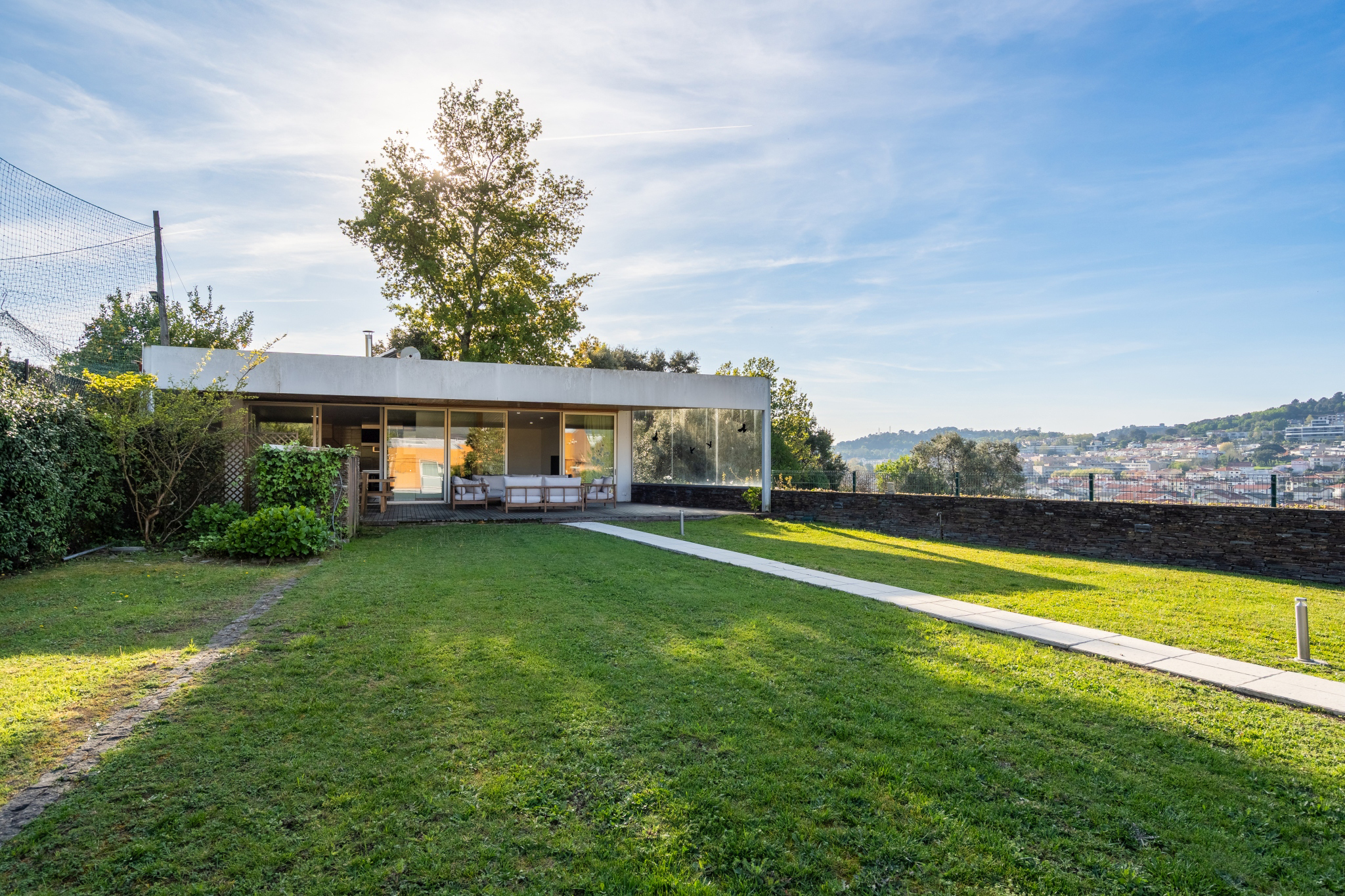 The Guest House — a glass pavilion in the garden, the valley beyond.