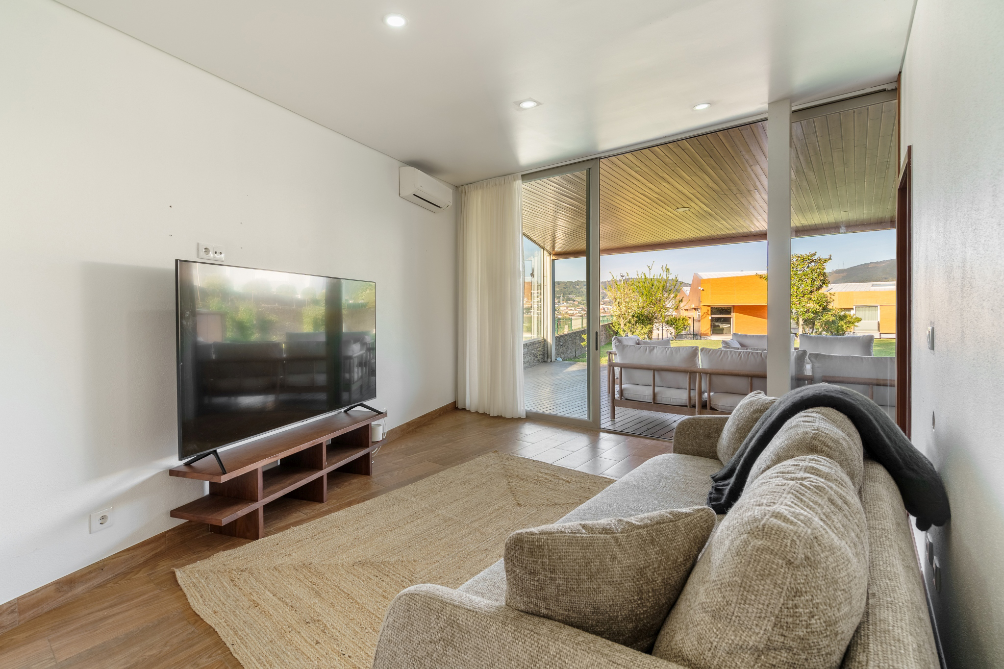 The Guest House — living room with television, opening to the terrace.