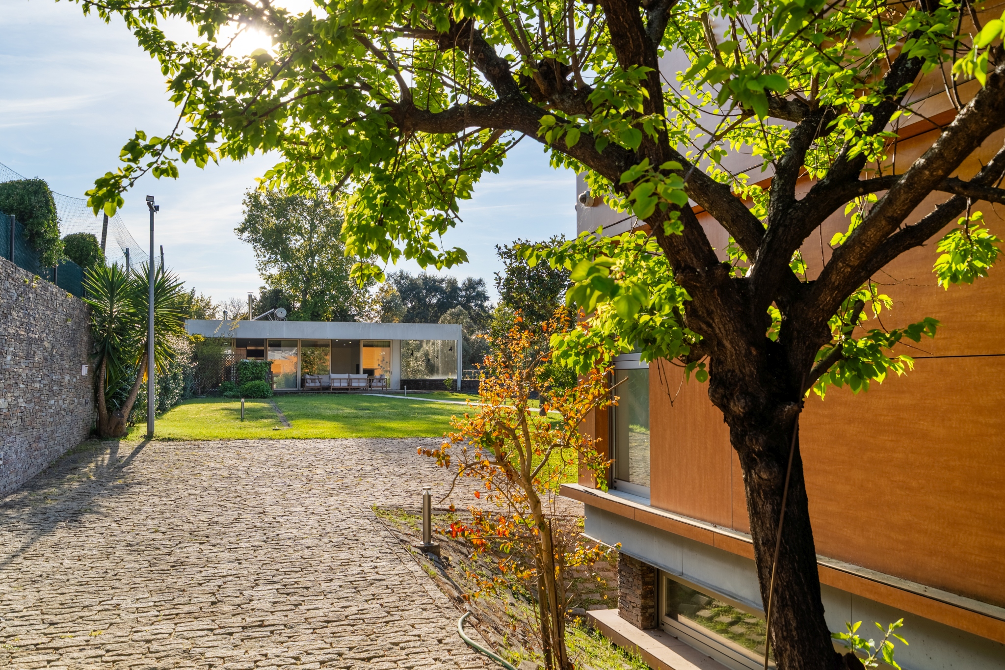 The driveway and garden at Matos Essence Villa in late sun.